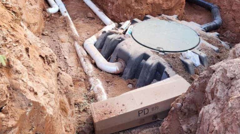 Septic tank and plumbing set in a rocky excavation during an alternative septic installation near Rimrock, AZ.